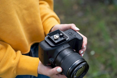 Person holding a camera with a 44mm Quick Release Tripod Plate Mount Adapter For Cameras And Video Gear Universal 1 3 4 Inch Square Base.