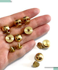 Top Shelf Solid Brass Bottom Guards For Handbags And Totes Round Screwback Feet 8 Pack shown in hand, including kickstands and screws.