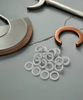 30 Pair M10 Double Layer Self Locking Wedge Shaped Anti Vibration Safety Washers Built From Heavy Manganese Steel on a workspace.