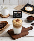 Latte with Ceramic Sugar Packet Holder And Tea Bag Organizer In Black on rustic table setup.