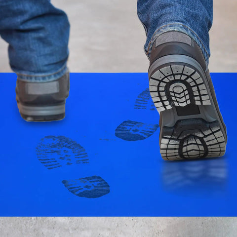 Person walking on Heavy Duty Tear Away Sticky Adhesive Floor Mats 36 By 18 Inch Grit Eater with footprints visible.