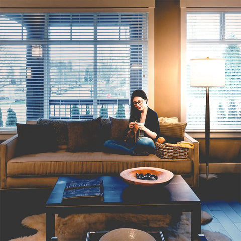 Lucas LED Floor Lamp With Drum Shade And Warm Wood Finish beside sofa in living room setting, creating ambient lighting.