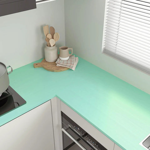 Thick Pastel Mint Metallic Peel And Stick Wallpaper With Brushed Matte Surface Gives Your Space A Straight Up Glow Up Self Adhesive Removable Backsplash For Quick DIY Upgrades on a kitchen countertop.