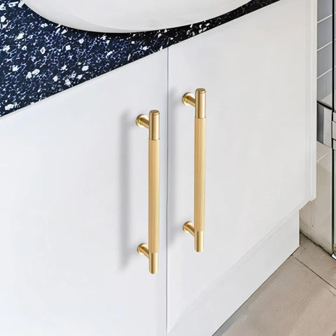 Top Shelf Solid Brass Cabinet Pulls Featuring Slick Brushed Gold Finish on white cabinets with navy countertop.