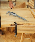 Digital Vernier Caliper 0-150mm Stainless Steel LCD(With battery) on a wooden workbench in a workshop.