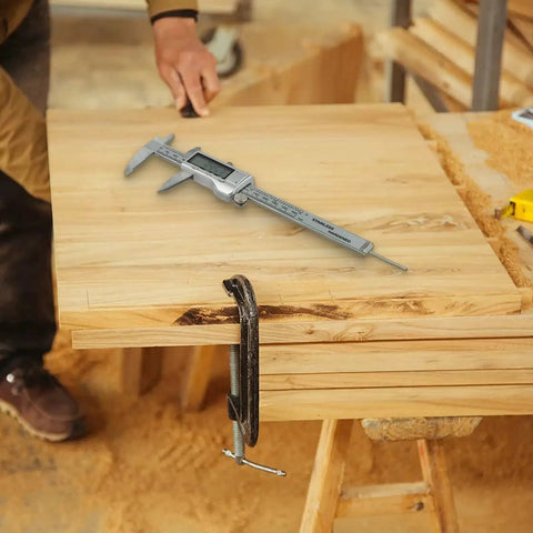 Digital Vernier Caliper 0-150mm Stainless Steel LCD(With battery) on a wooden workbench in a workshop.