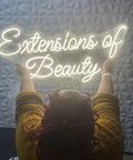 Person hanging personalized neon LED sign for weddings and events, battery or plug operated lit up name logo, wall decor