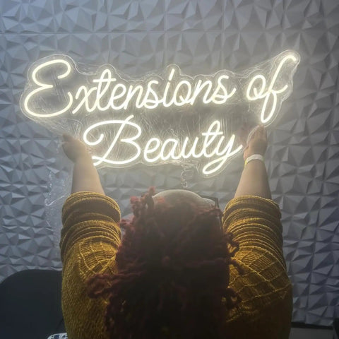 Person hanging personalized neon LED sign for weddings and events, battery or plug operated lit up name logo, wall decor