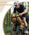 Cyclist using Bike Handlebar Harness For Bikepacking With Front Rack System And Flexible Mounting Options Big Capacity Fits Dry Bags From 3 To 12 Liters Easy Quick Tighten Webbing For Adjustable Storage On The Go in forest.