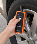 Pro TPMS Reset Tool For Fast Tire Pressure Sensor Activation And One Button Relearn handheld device in use on a car tire.