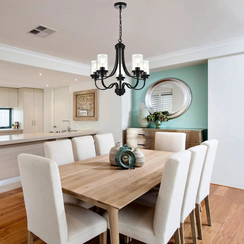 Affordable Luxury Five Light Farmhouse Chandelier In Classic Black Finish above dining table with pendant lighting and glass shades.