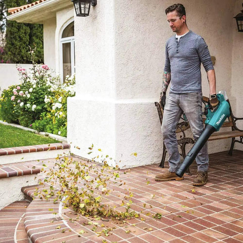 Man using 18V LXT Brushless Cordless Blower With Cruise Control, Variable Speed Trigger, And Speed Lock For Continuous Operation, Tool Only, on patio