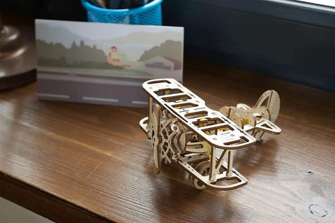 Mini Biplane 3D Puzzle Kit For Adults, Wooden Mechanical Model, DIY Craft Project, 3.15 Inch High, Hands-On Aviation Lover Gift, Classic Biplane Design, Challenging Build For Puzzle Fans And Flight Nerds on wooden desk