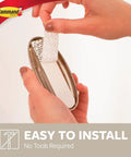 Applying adhesive strip to Brushed Nickel Coat Hook 5 Lb With No Drill Adhesive Strips Damage Free Wall Mount Includes 1 Hook And 2 Strips
