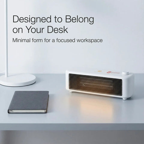 Graphene Far Infrared Mini Desk Heater for Personal Office Use on desk next to notebook and lamp, showing compact design.
