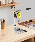 Jzswyst Heavy Duty Aluminum Drill Press Stand With 90 Degree Rotating Adjustable Bench Clamp For Hand Drill on a workbench with materials.