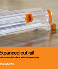 Precision Paper Trimmer With SureCut Wire Cut Line And TripleTrack System showing expanded cut rail on wooden surface.