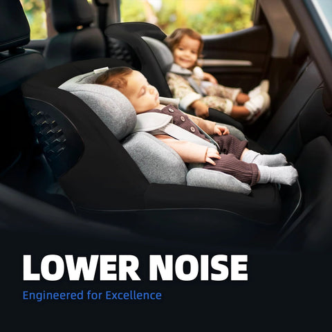 Child in car seat, rear-facing, with another child in the background, text overlay stating 'Lower Noise' and 'Engineered for Excellence'.