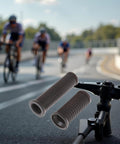 Dual Length Black Bike Handlebar Grips for Twisting Shifters mounted on bike stem, cycling race in background