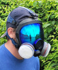 Side view of person wearing Dope Full Face Respirator Mask for wildfire smoke, with eye protection and dual filter, reflecting surroundings.