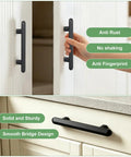 "Ten Pack 3 Inch 76mm Hole Centers Matte Black Solid Zinc Alloy Cabinet Handles And Drawer Pulls Built Tough For Modern Kitchen Bathroom Cupboard Dresser And Closet" shown in use on white cabinet and drawer with smooth finish.