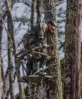 Hunter using Titan Sd Climbing Treestand With Roomier Design Bigger Top Seat Frame And Longer Foot Platform For Large Frame Hunters