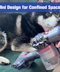 Mini Hair Screw Vacuum Attachment With Anti Tangle Conical Brush for Dyson being used near a dog on a couch for pet hair cleaning.