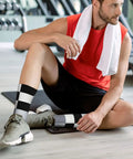 Top Shelf Black And White Piano Plate Grid Athletic Socks Engineered For The Daily Grind on a man in gym setting.