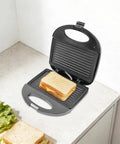 This Sweet 900 Watt Electric Sandwich Maker And Steak Grill Is A Total Game Changer For Your Kitchen Or Office Setup, featuring a sandwich placed inside.