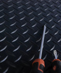 Heavy Duty Vinyl Diamond Plate Floor Mat Non Slip Garage Flooring Chemical Resistant One Eighth Inch Thick By Twenty Four Wide By Eight Feet Long Black With Yellow Border with screwdrivers on top