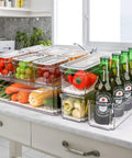 10 Pack Refrigerator Pantry Organizer Bins With Lids To Keep Your Snacks Chill And Food Stash Tidy storage with clear bins holding fruits and vegetables.