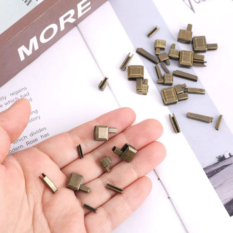 Hand holding bronze zipper parts from Go To Zipper Bottom Stopper Kit Set With Latch Slider Retainers And Insertion Pins For Coats Jackets And Bags Includes 4 Size Options 3 5 8 10 Bronze Metal Zipper Repair Parts For DIY Sewing Fasteners Replacement