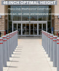 Built Like A Tank Hdpe Bollard Cover 5 X 46 Inch Grey Push On Post Sleeve With Two Add On Reflective Collars lined up in front of a store.