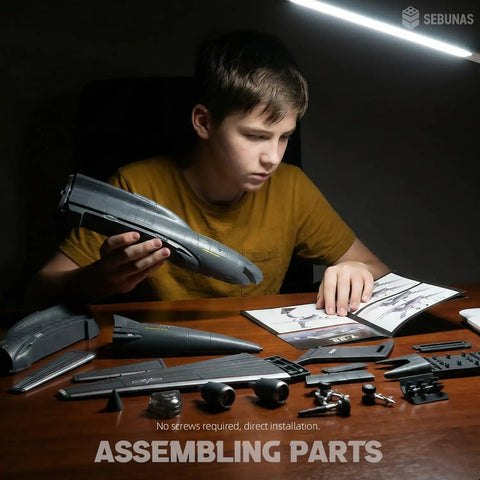 Child assembling One To One Hundred Scale Y 20 Transport Aircraft Quick Assembly Model Kit Plastic Airplane With Stand No Glue Needed Easy Snap Together Fun Toy For Kids Gift at desk under lamp.