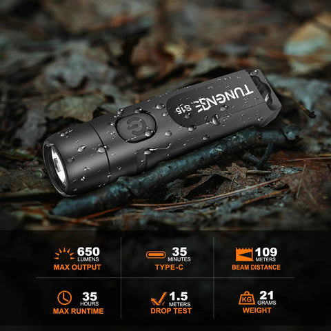 Rechargeable Keychain Flashlight 650 Lumens EDC Pocket Light on forest ground with water droplets, fast USB C charging