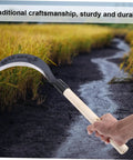 Long Handle Manganese Steel Hand Scythe for Weeding and Uprooting in the Garden, durable tool held in a field background