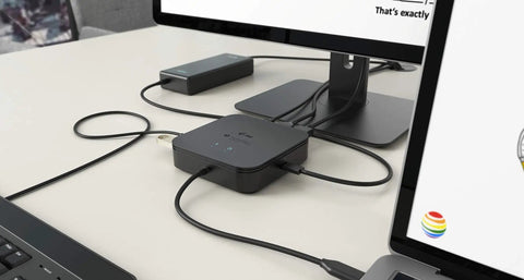 Thunderbolt 3 Travel Dock providing dual 4K screen space on an office desk, connected to laptop and monitors.