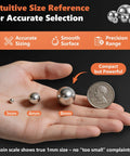 Hand holding 1mm to 8mm balls from 650 Piece 304 Stainless Steel Bearing Balls Set for DIY Projects showing size with a coin for scale.