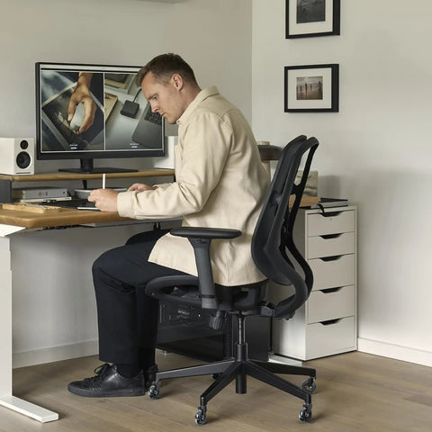 Man sitting on an office chair with installed Office Chair Wheel Replacement Set Of 5 11x22mm 3 Inch Black Polyurethane Casters.