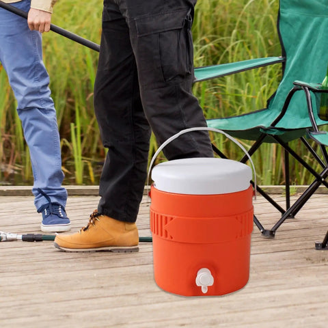 Portable Sports Drink Dispenser With Heavy Insulation Keeps Backyard Faves Stay Frosty All Weekend And Sip Smooth At Tailgates While Hanging Out In Vibrant Orange placed on wooden deck by fishing chairs.