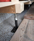 Adjustable Leveling Jacks in black and galvanized steel supporting wood beams for saggy floor fix, height adjustment 5 to 8 inch.