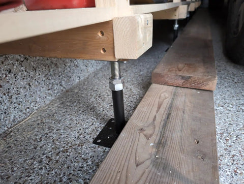 Adjustable Leveling Jacks in black and galvanized steel supporting wood beams for saggy floor fix, height adjustment 5 to 8 inch.