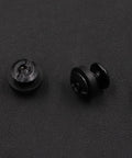 Close-up of two 96-Piece Beefy Black Chicago Screws For Leather And Kydex Holsters And Knife Sheaths on a black surface