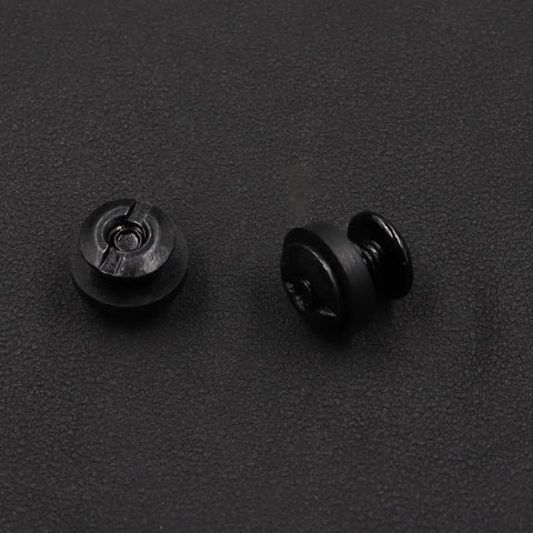 Close-up of two 96-Piece Beefy Black Chicago Screws For Leather And Kydex Holsters And Knife Sheaths on a black surface