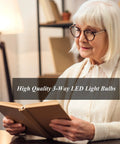 Person reading under A21 LED Three Way Light Bulb With Low Medium High Settings, 2200 Lumens Daylight 5000K, 4 Pack