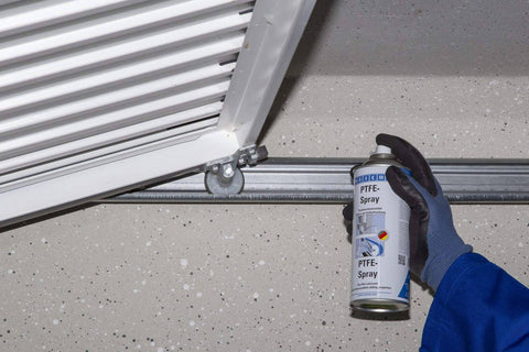 Hand applying Grease-Free Dry PTFE Lubricant Spray For Metal, Plastic And Wood Surfaces on a metal hinge, silicone free, 13.5 oz can.
