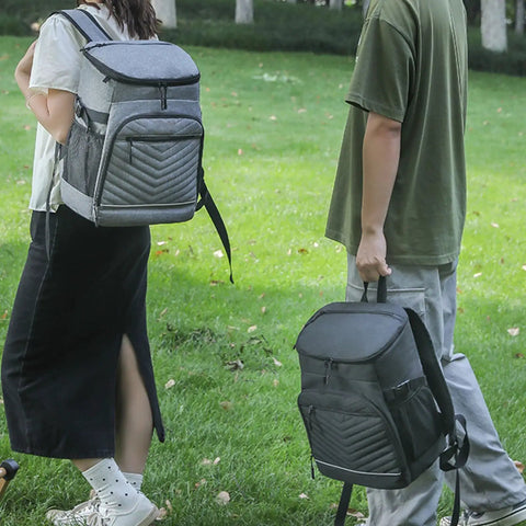 Kickass Heavy Duty Insulated Cooler Backpack With Leakproof Thermal Core And Adjustable Padded Straps For Camping Beach Hiking Keeps Snacks Ice Cold No Sweat seen worn by two people outdoors.