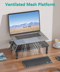 Go To Adjustable Desk Monitor Stand With Laptop Riser And Under Desk Storage, black metal frame holding a laptop on a wooden desk.