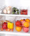 Total Game Changer Clear Plastic Storage Bins Eight Pack Of See Through Pantry Organizers And Fridge Containers arranged in a refrigerator with fruits and vegetables.