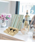 Multi Grid Watch Organizer Tray With Linen Padded Sections displaying two watches on a vanity against decorative items.